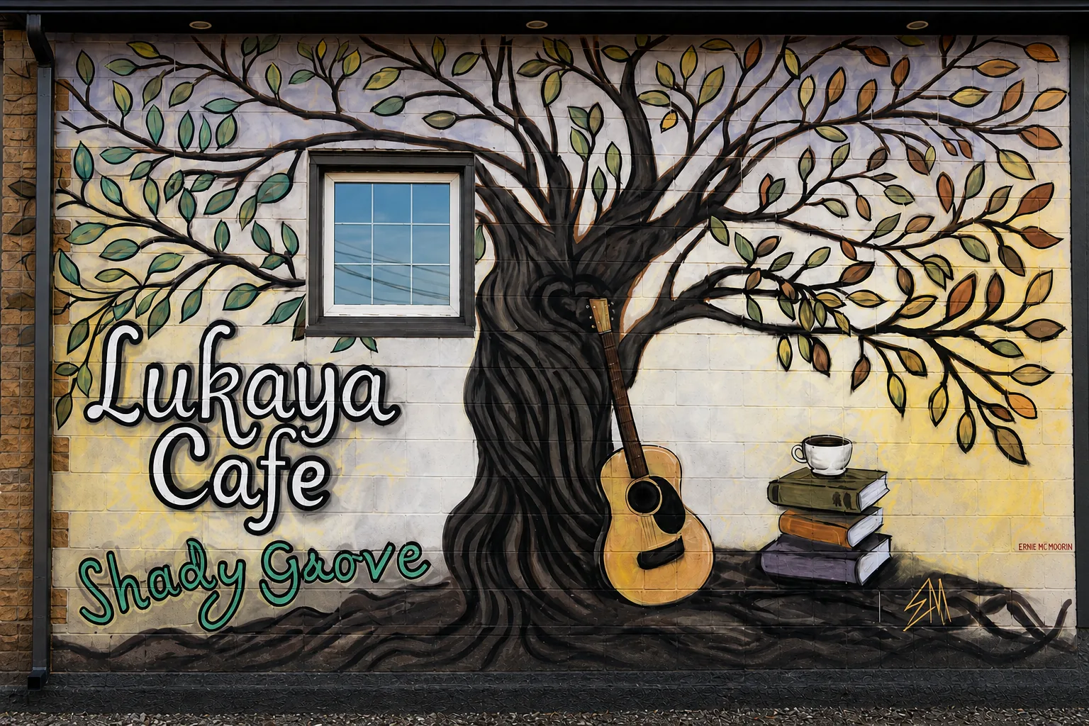 A straight-on view of Lukaya Cafe's hand-painted tree, guitar, books and teacup mural